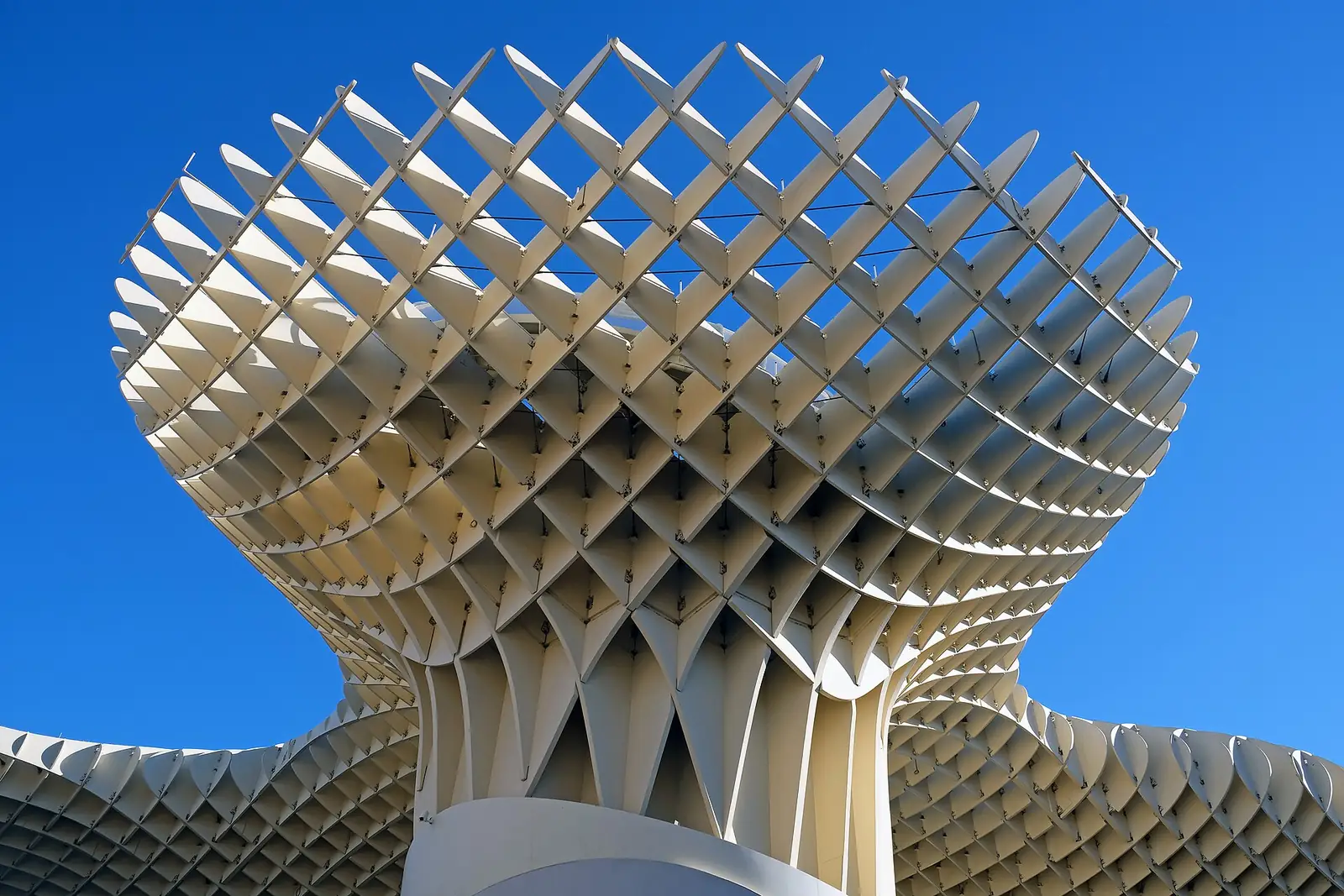The white wooden lattice of the Metropol Parasol rising against a blue sky on Plaza de la Encarnación